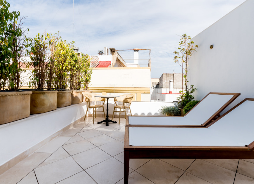 Penthouse terrace equipped with table, chairs and hammocks. 