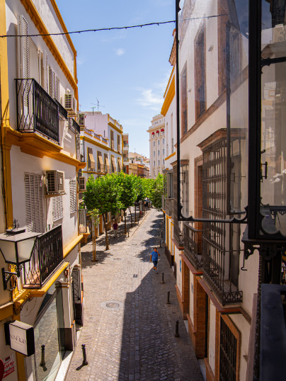 Blick vom Balkon auf eine Straße im Zentrum von Sevilla.